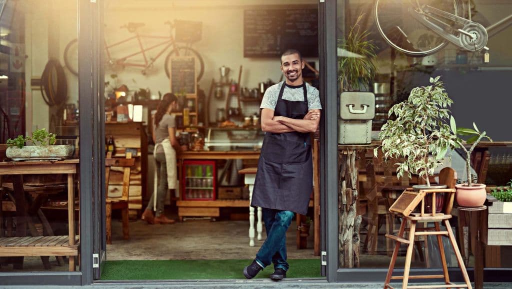 business owner standing at entrance of business